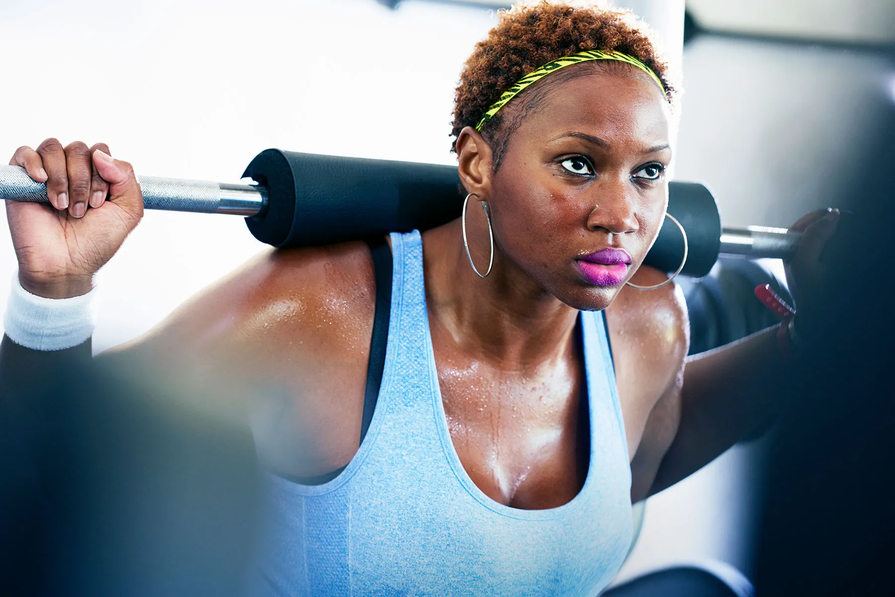 photo of woman lifting weights at gym