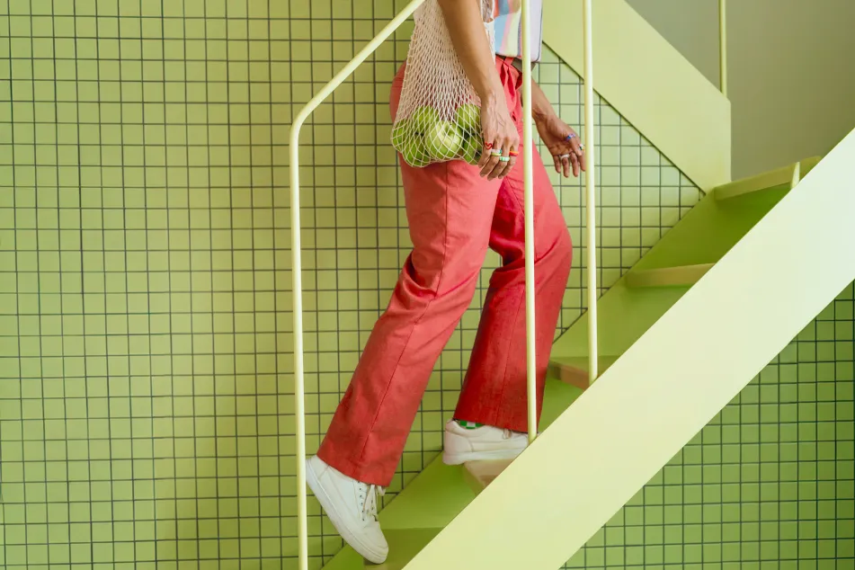 photo of a woman walking up colorful stairs