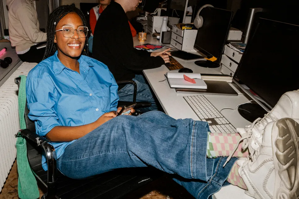 photo of smiling female sitting with feet up on table at office