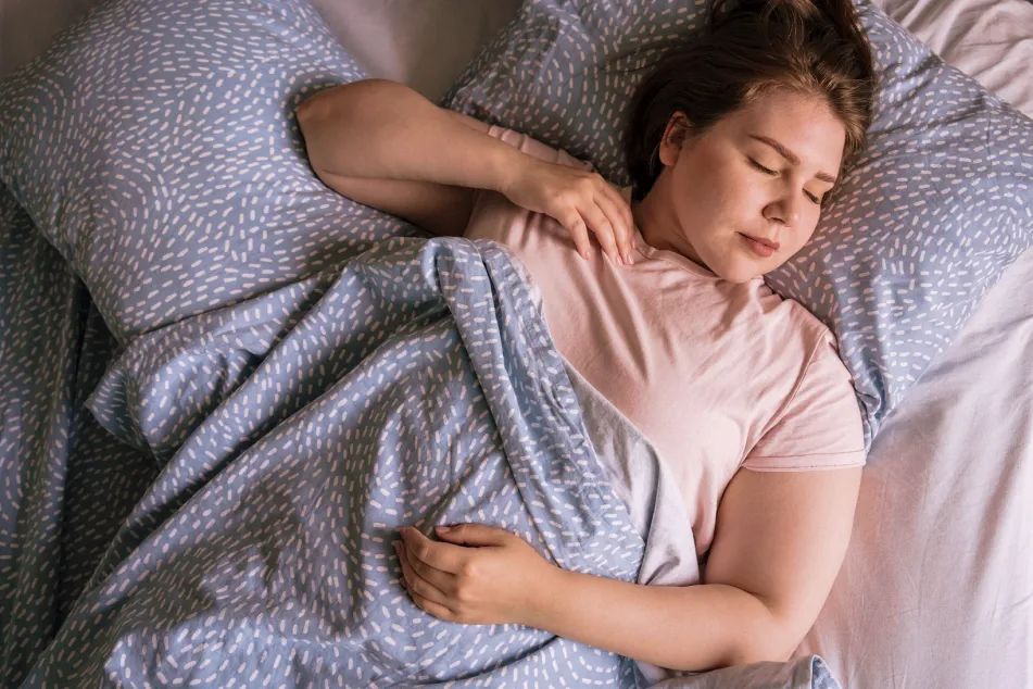 photo of a young woman sleeping on bed at home