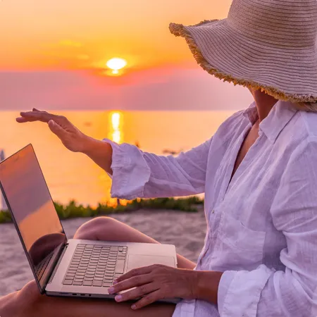 photo of  a woman closing laptop while relaxing on chair and looking at beautiful sunset