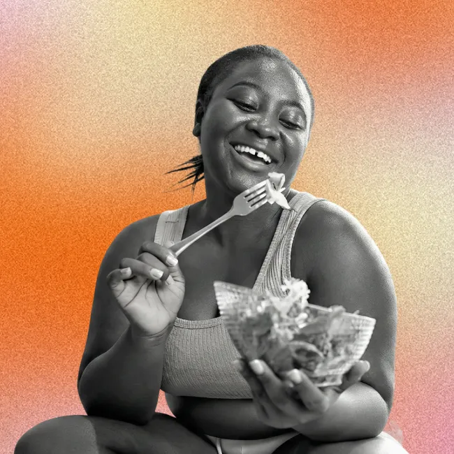 photo of a Black young smiling and eating salad