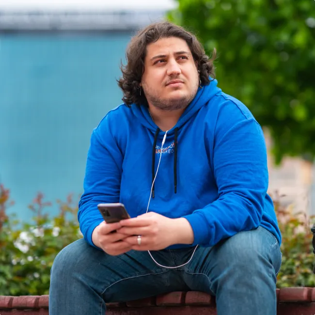 photo of a full figured man using a mobile phone in park