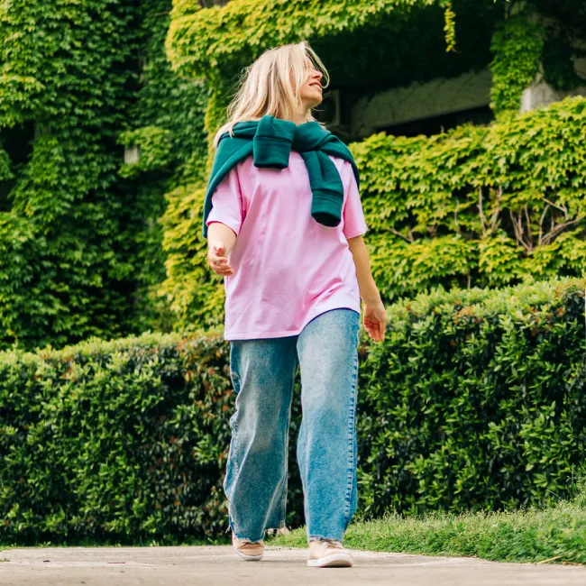 photo of woman walking in green ivy