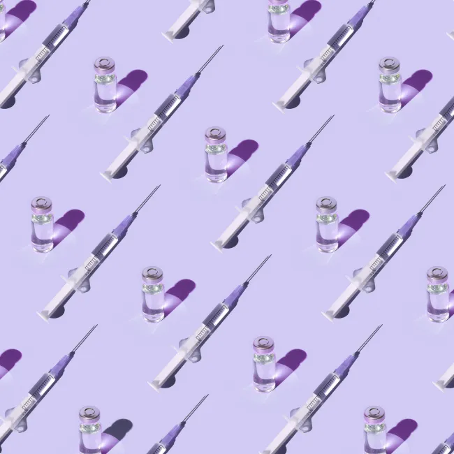 photo of a pattern of vials and syringes with a vaccine on a purple background