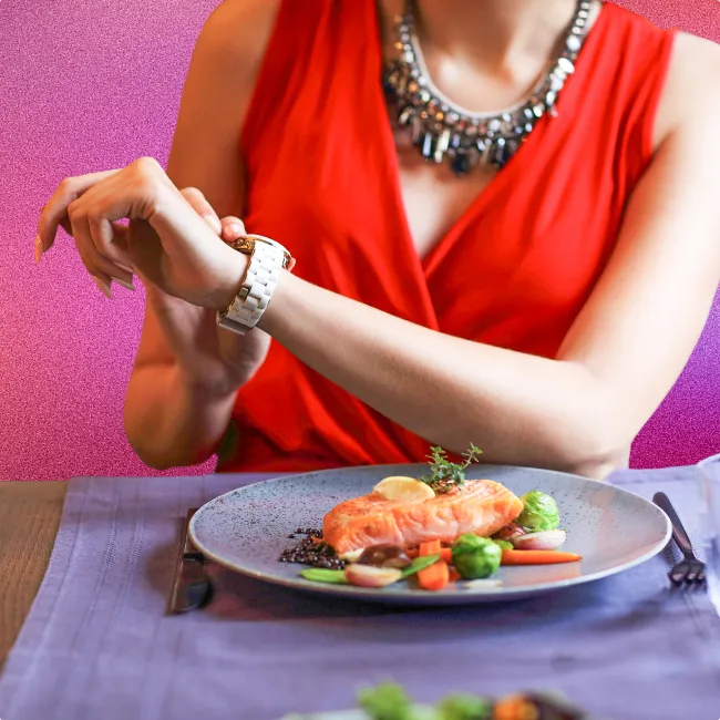 photo of a woman at a restaurant looking at her watch