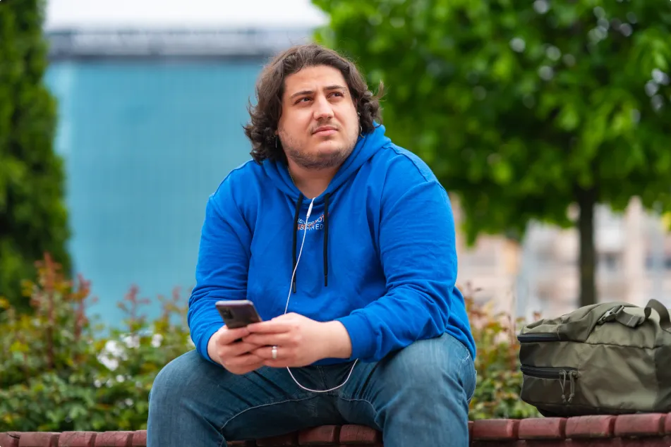 photo of a full figured man using a mobile phone in park