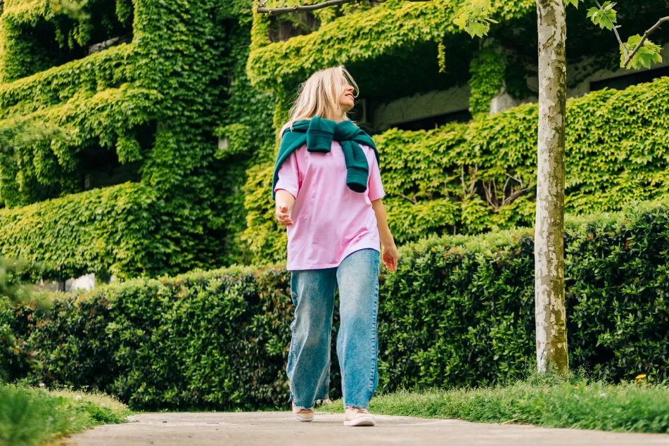 photo of woman walking in green ivy