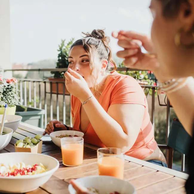 photo of  friends eating meal on balcony