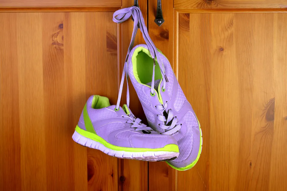 photo of purple sneakers hanging in front of a wooden closet