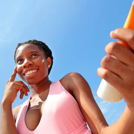 photo of woman applying sun cream