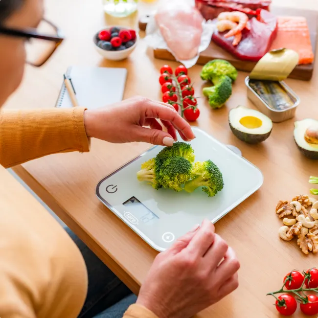 photo of woman weighing food on scale