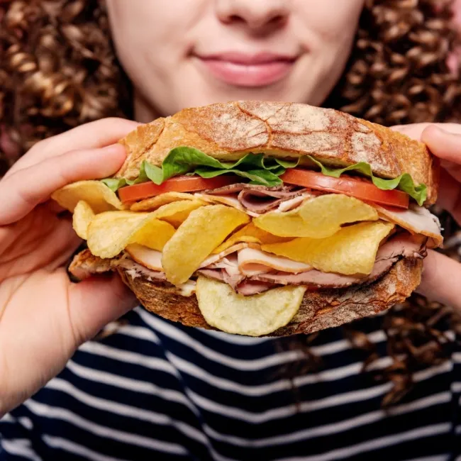 photo of woman holding sandwich