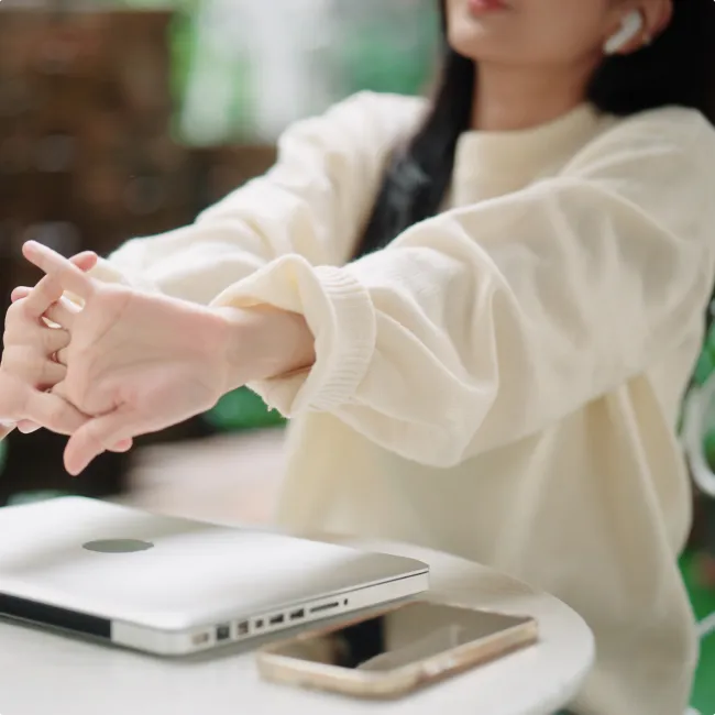 photo of woman stretching after working on laptop
