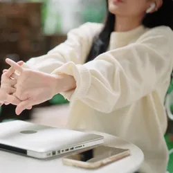 photo of woman stretching after working on laptop