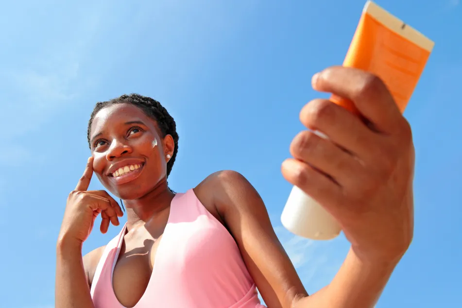 photo of woman applying sun cream