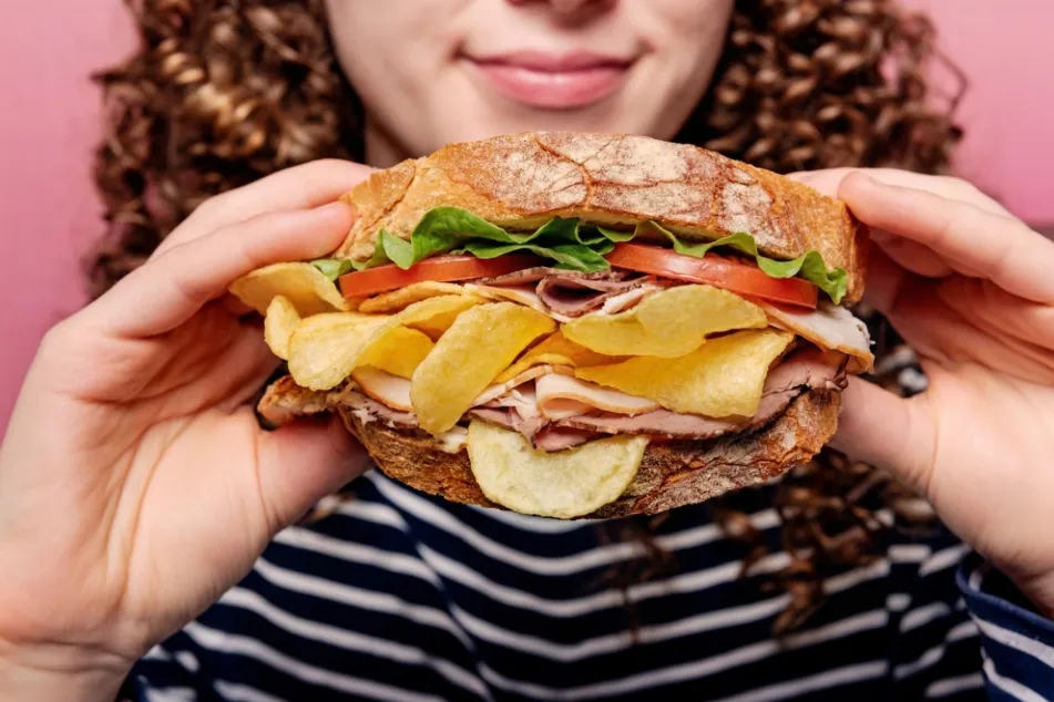 photo of woman holding sandwich