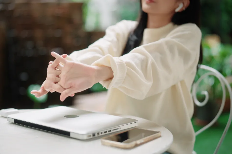 photo of woman stretching after working on laptop