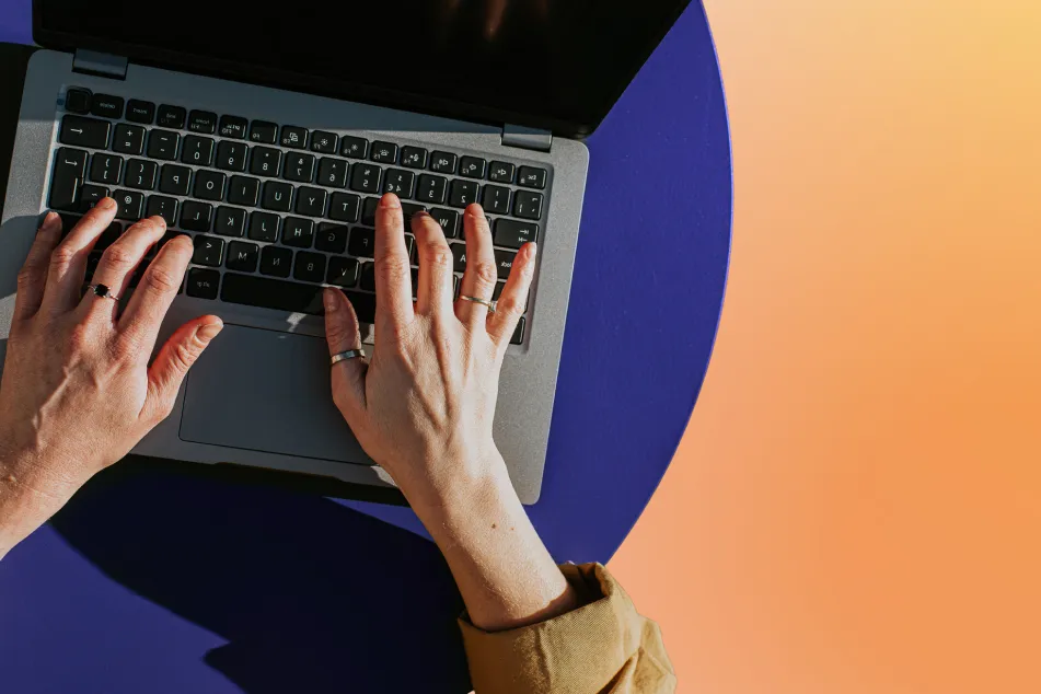 photo of hands typing on a laptop keyboard