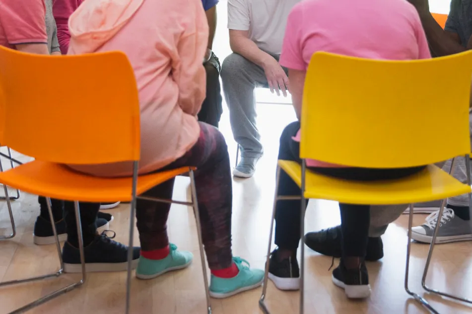 photo of seniors talking in circle in community center
