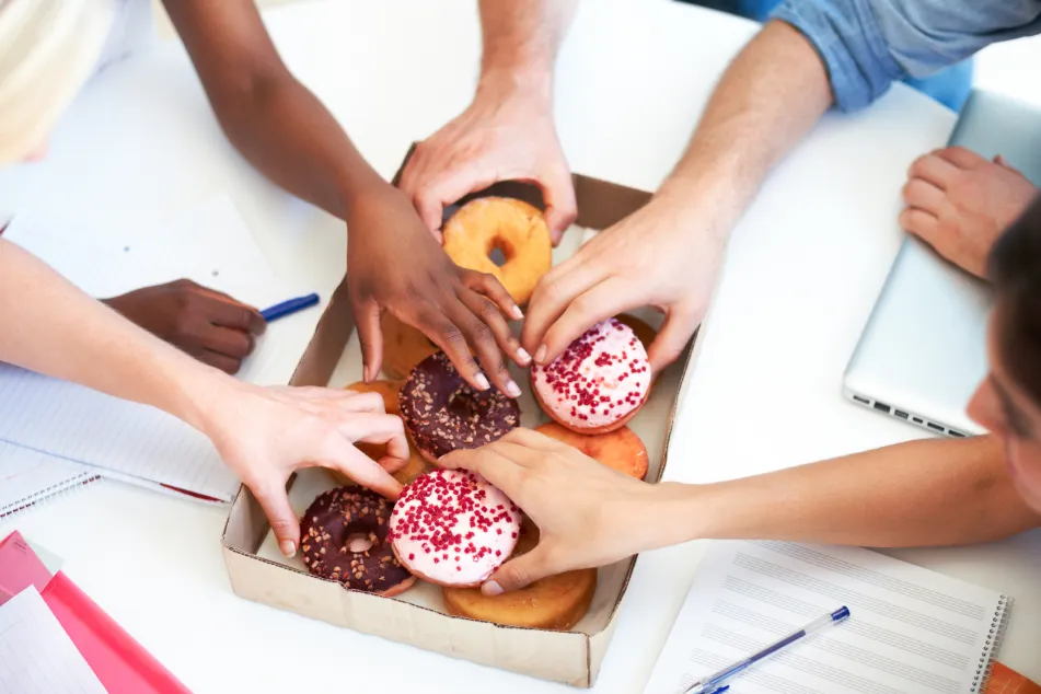 photo of group reaching for donuts