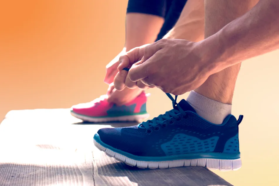 photo of tying their shoes on a bench in a park