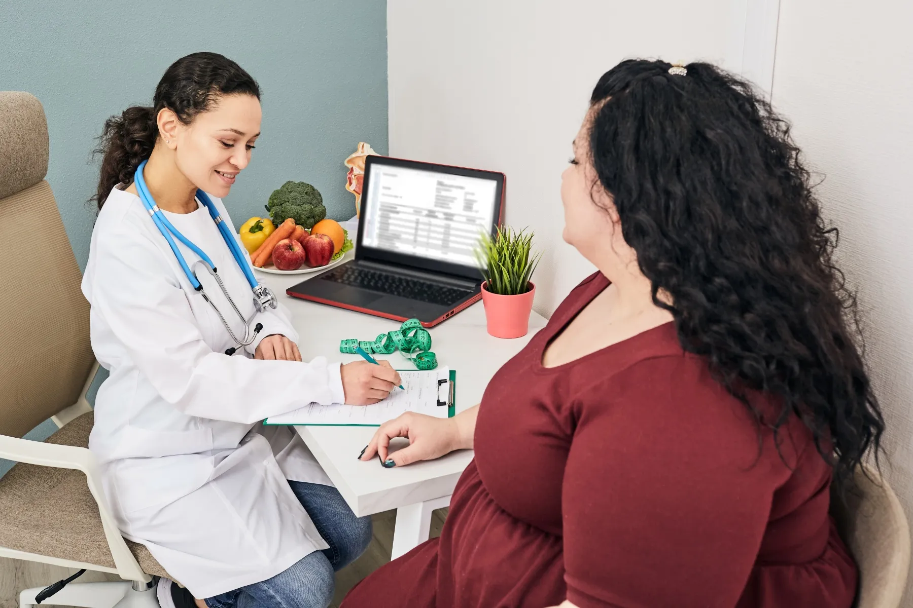 photo of nutritionist discussing diet plan with obese patient